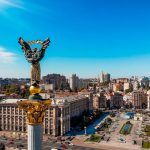 a view of a city with a statue in the middle